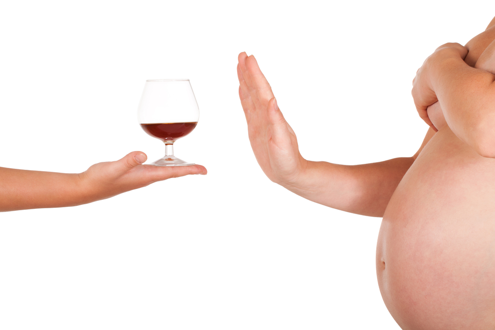 Pregnant woman rejects of taking glass of alcohol.